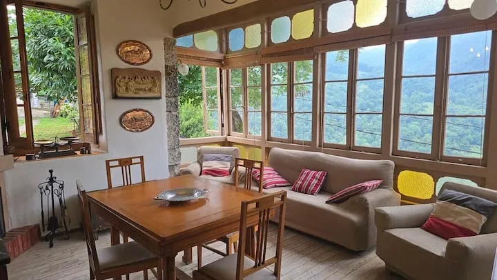 Salón acristalado de Donde Alicia con vidrieras y vistas a la montaña